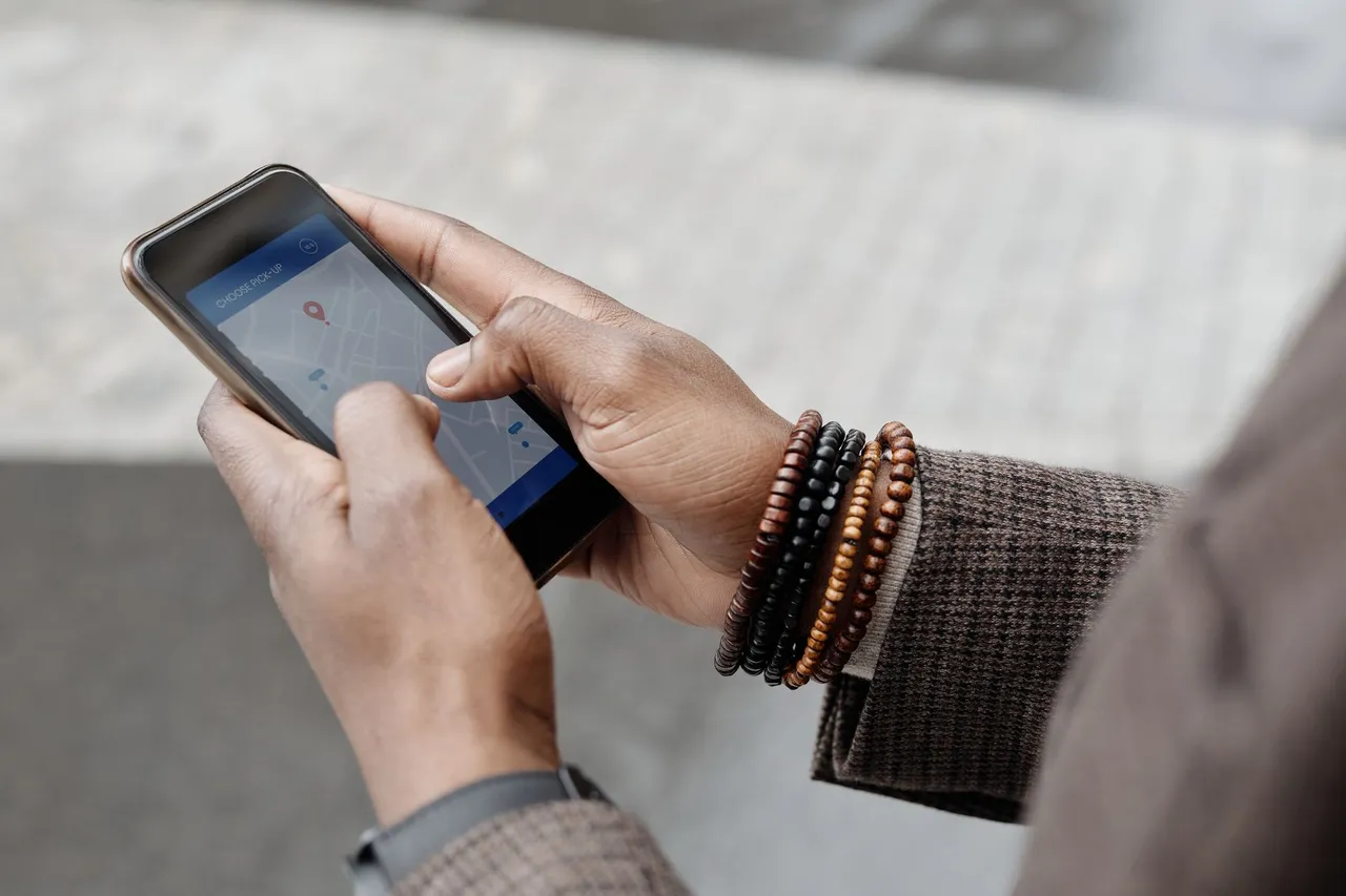 Personne utilisant une application de navigation GPS sur son smartphone pour trouver un commerce à proximité.