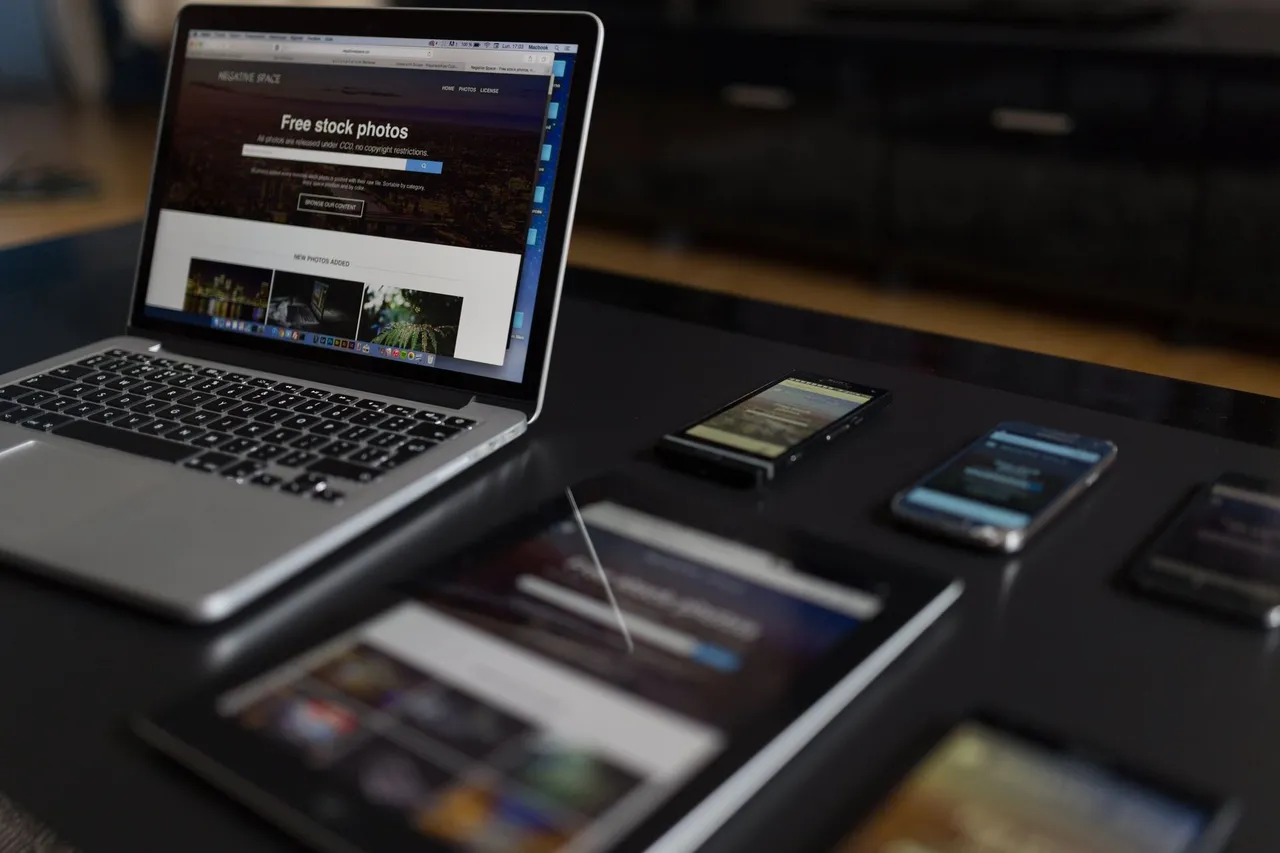 Poste de travail avec un ordinateur portable, une tablette et un smartphone affichant un site web responsive.